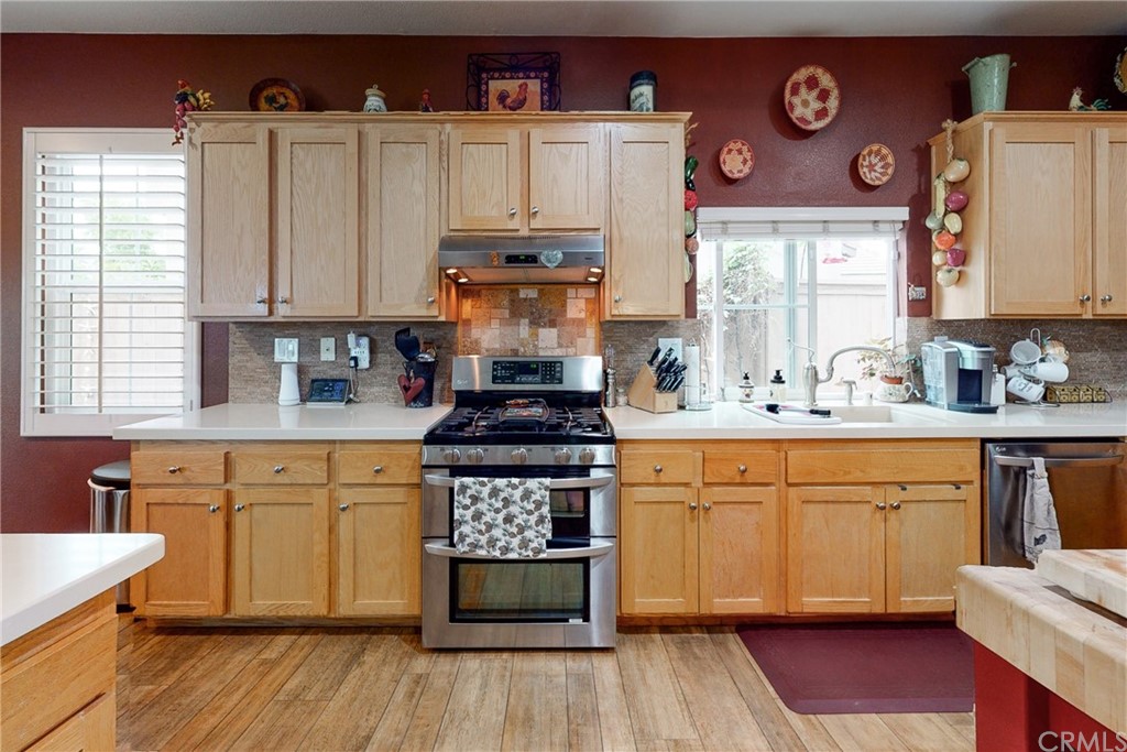 3199 Toopal Drive Oceanside, CA 92058 - Photo 14 of 47 a kitchen with stainless steel appliances granite countertop a stove a sink and white cabinets with wooden floor