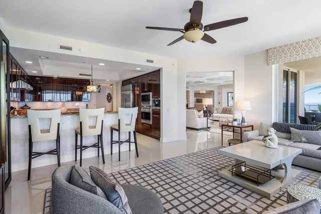 a living room with dining room and chandelier