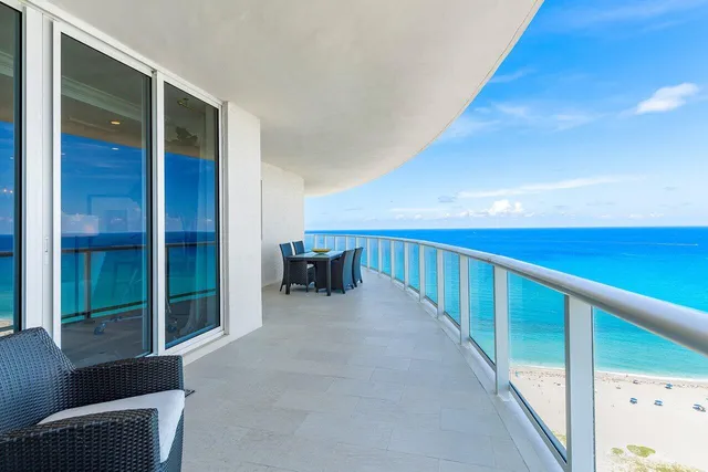 a view of a balcony with floor to ceiling windows with wooden floor