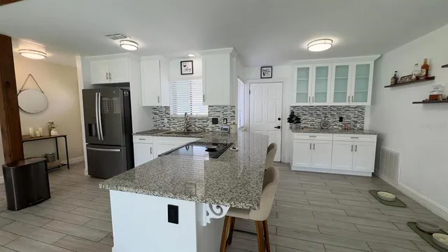 a kitchen with stainless steel appliances granite countertop a sink a stove and refrigerator