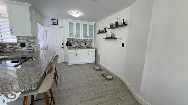 a kitchen with cabinets and wooden floor