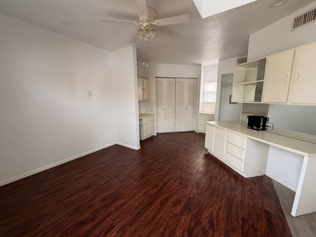 a kitchen with wooden floors and white cabinets