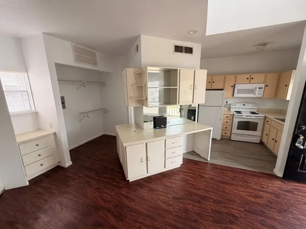 a kitchen with white cabinets and white appliances