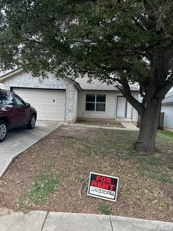 a view of a house with a cars park side of a road