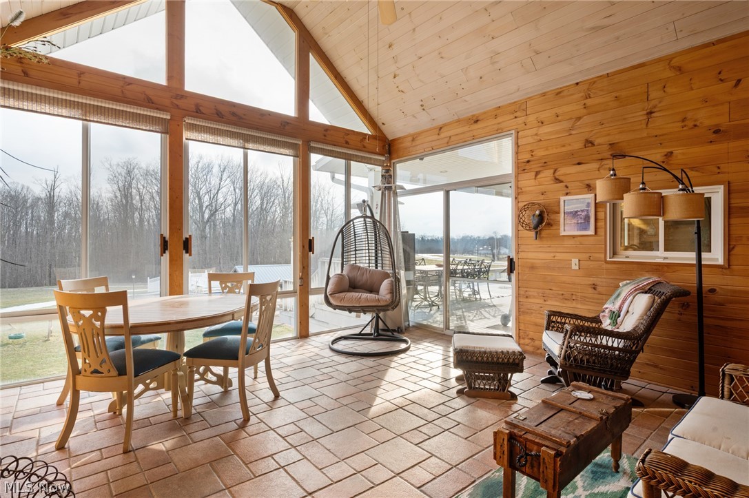 9419 Robinson Road Chardon, OH 44024 - Photo 8 of 46 Sunroom featuring wood walls, stone tile floors, and a vaulted wooden ceiling