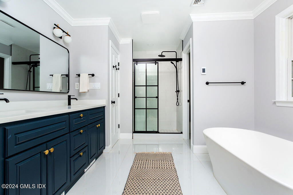 25 Griffith Road Riverside, CT 06878 - Photo 13 of 27 a spacious bathroom with a double vanity sink a large mirror a bathtub and shower