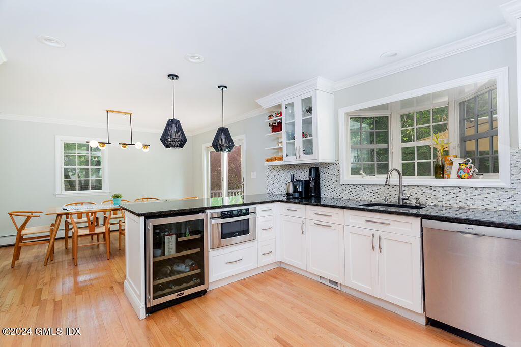 25 Griffith Road Riverside, CT 06878 - Photo 6 of 27 a kitchen with granite countertop a stove a sink a dining table and chairs