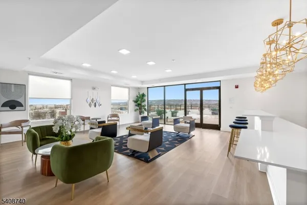a kitchen with stainless steel appliances kitchen island granite countertop a table chairs and a wooden floor
