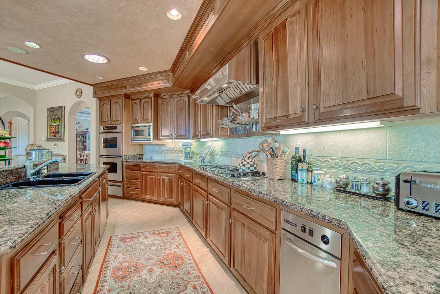 2703 Brush Creek Road Santa Rosa, CA 95404 - Photo 41 of 76 a kitchen with kitchen island granite countertop wooden cabinets a sink and dishwasher