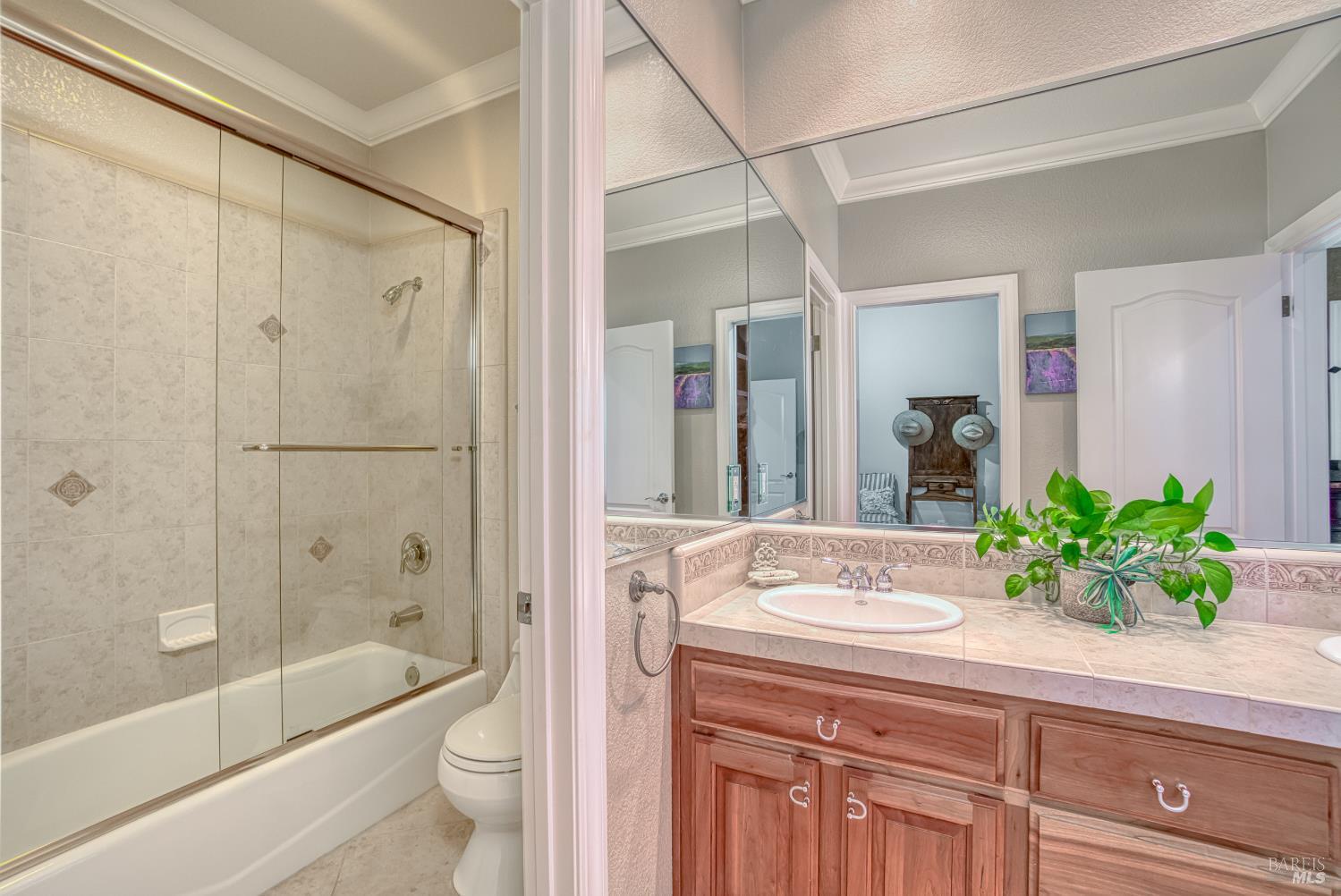 2703 Brush Creek Road Santa Rosa, CA 95404 - Photo 60 of 76 a bathroom with a granite countertop sink a toilet a mirror a bathtub and shower