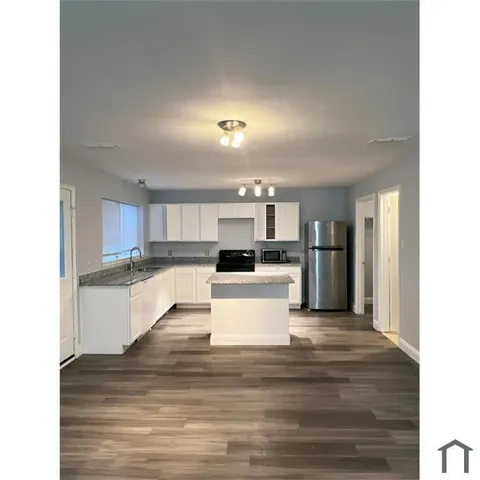 a view of kitchen with refrigerator stove microwave and cabinets
