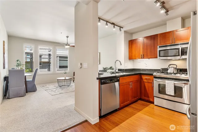 a kitchen with stainless steel appliances granite countertop a stove a sink and a microwave