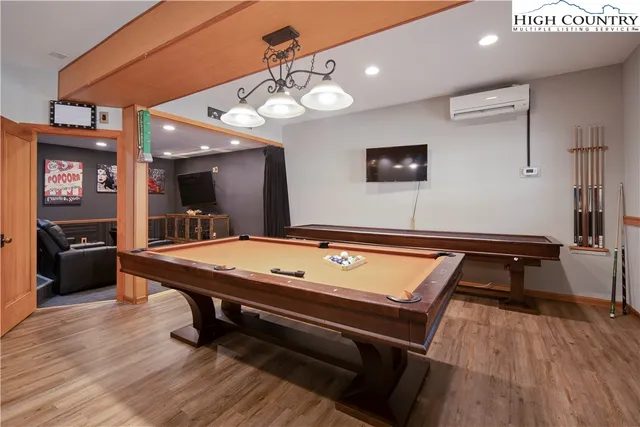 a room with pool table and wooden floor