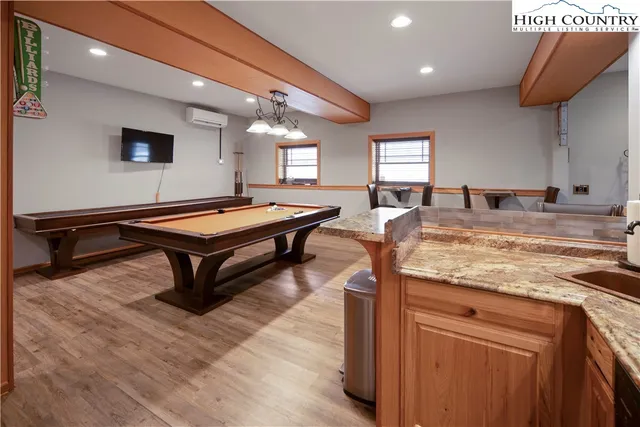 a room with pool table table and windows