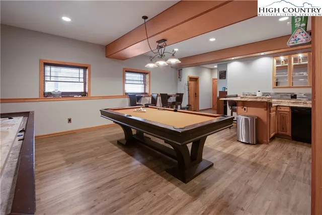 a room with pool table and windows