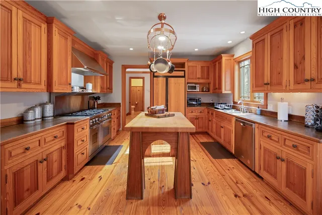 a large kitchen with stainless steel appliances granite countertop a stove a sink dishwasher and wooden cabinets