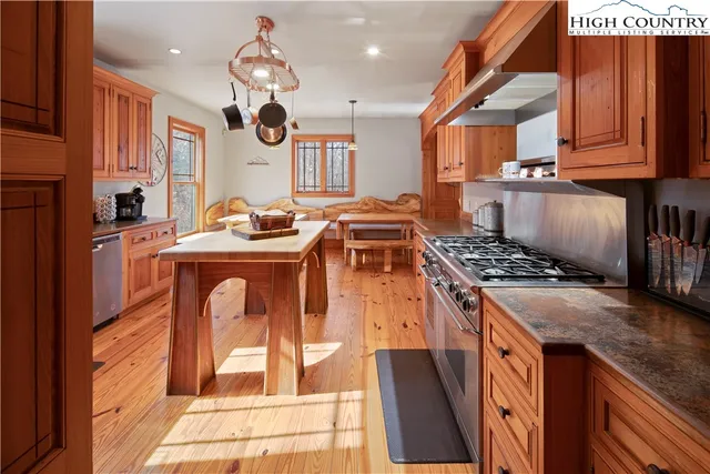 a kitchen with stainless steel appliances granite countertop a stove a sink and a microwave