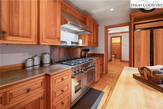 a kitchen with stainless steel appliances granite countertop a stove a sink and a refrigerator