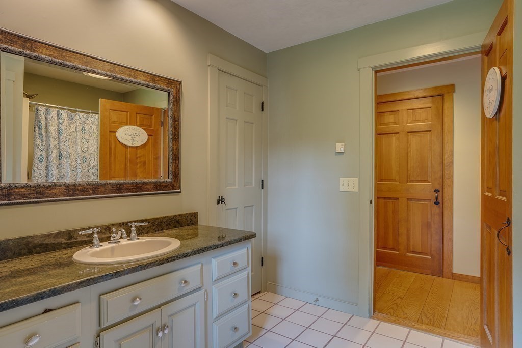 916 Chase Road Lunenburg, MA 01462 - Photo 35 of 42 a bathroom with a granite countertop sink vanity mirror and a