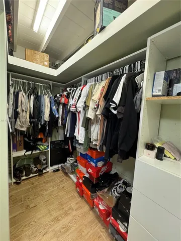 a view of walk in closet with clothes and shoes