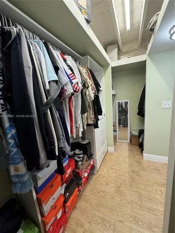 a view of walk in closet with clothes and shoes