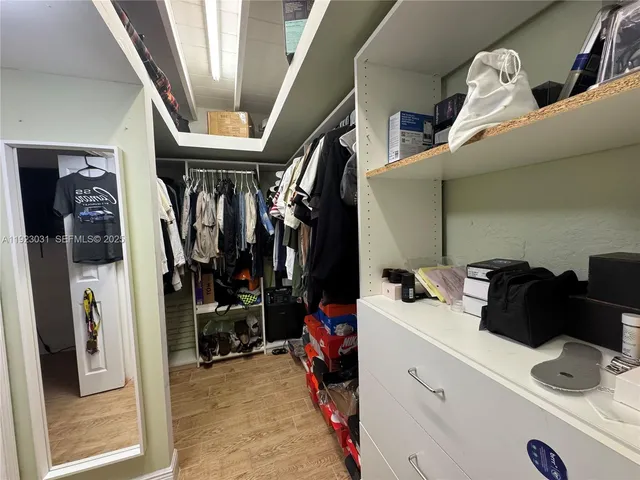 a kitchen with stainless steel appliances granite countertop a stove top oven a sink dishwasher and a refrigerator with wooden floor