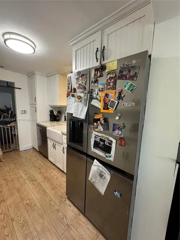 a kitchen with granite countertop white cabinets and stainless steel appliances