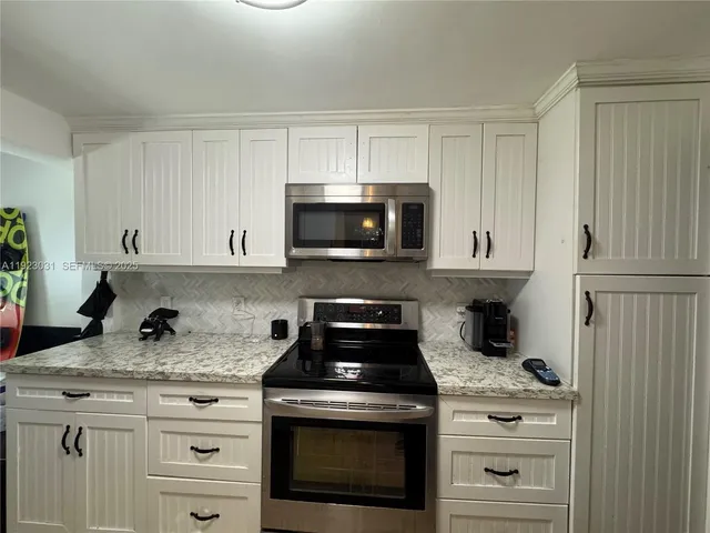 a view of a yard with plants and large trees