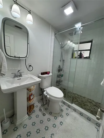 a bathroom with a sink toilet and shower