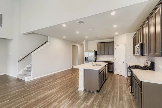a kitchen with stainless steel appliances granite countertop a sink stove and refrigerator