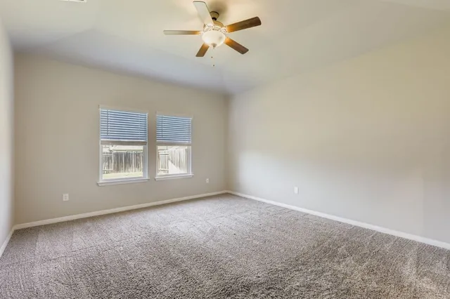 a view of a room with windows and chandelier fan