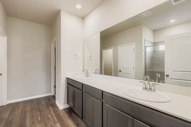 a bathroom with a double vanity sink and mirror