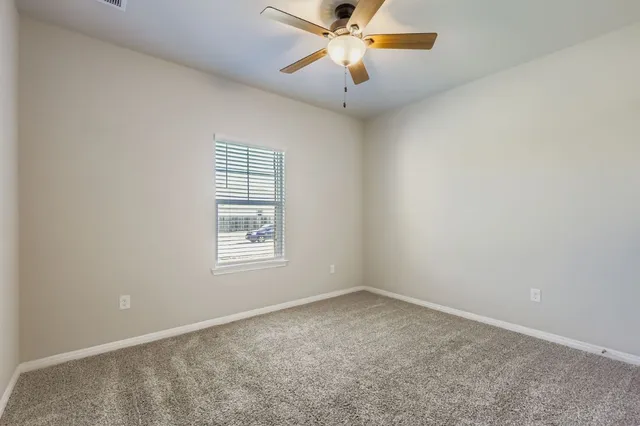 an empty room with a window and a fan