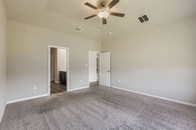 a view of an empty room and a ceiling fan