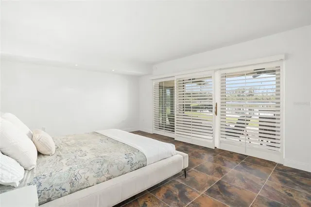 a bedroom with a bed and a large window