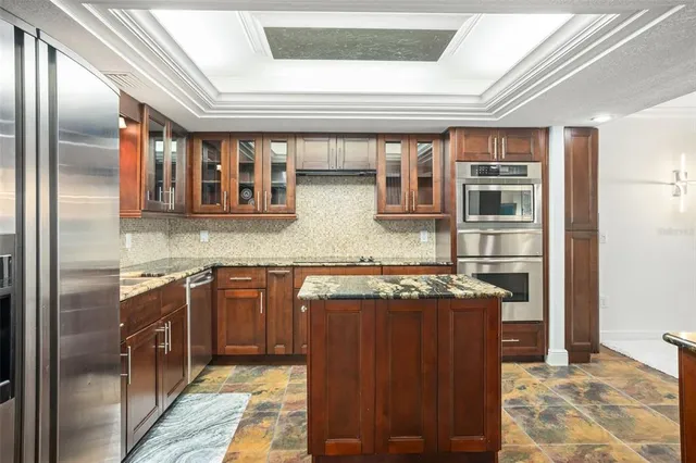 a kitchen with stainless steel appliances granite countertop a stove a refrigerator and a microwave