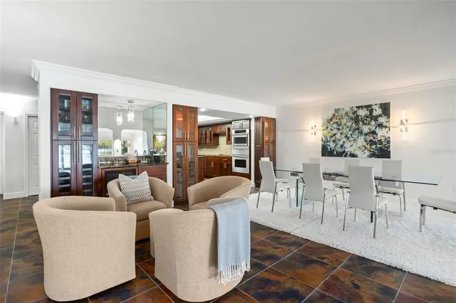 a living room with furniture a large window and wooden floor