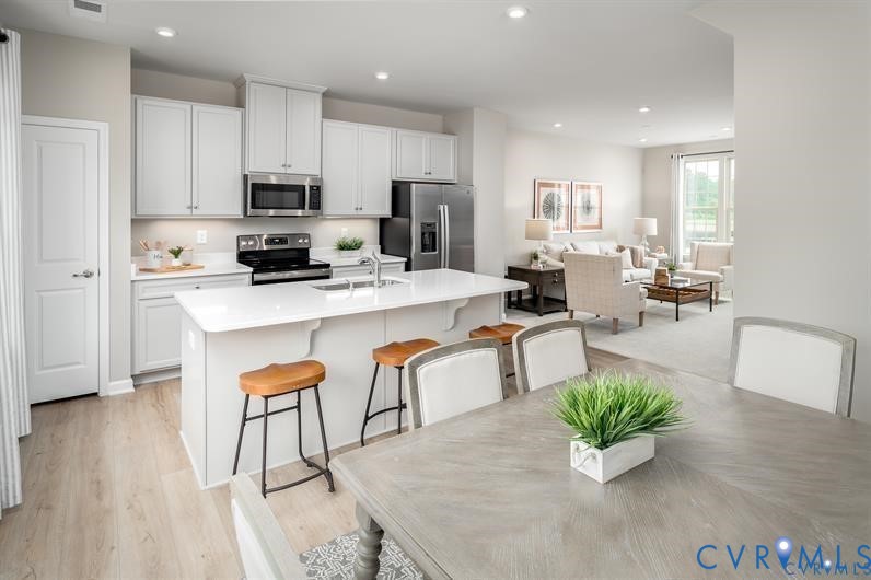 2132 Old Lime Road Sandston, VA 23150 - Photo 2 of 9 a kitchen with stainless steel appliances kitchen island granite countertop a refrigerator a stove a sink a dining table and chairs with wooden floor