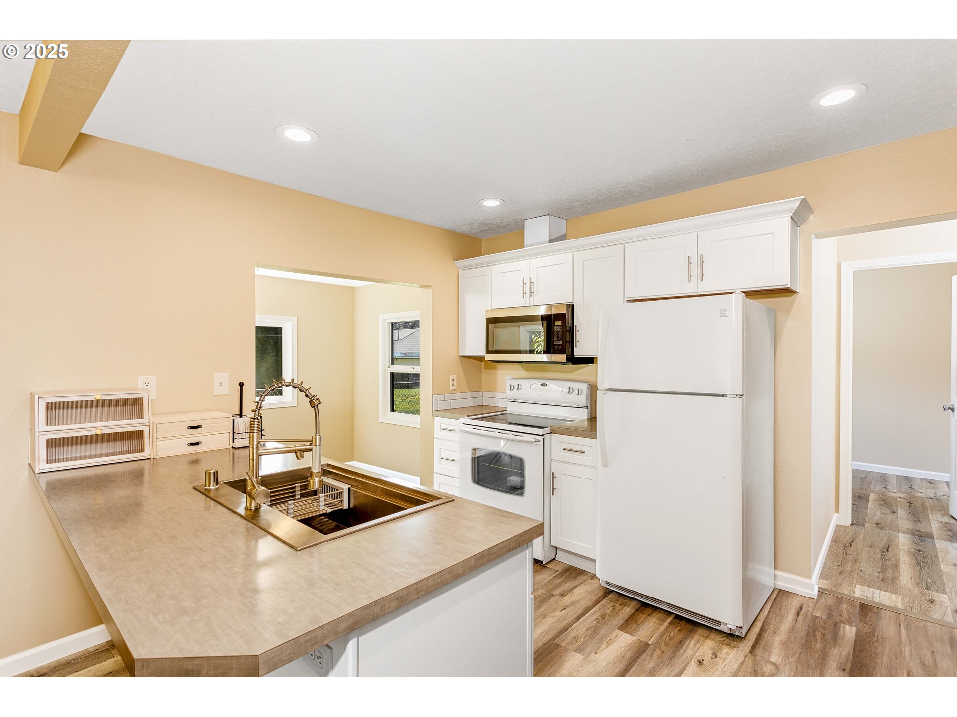 1617 7th Avenue Longview, WA 98632 - Photo 5 of 23 a kitchen with kitchen island a stove a refrigerator a sink dishwasher with a dining table and chairs