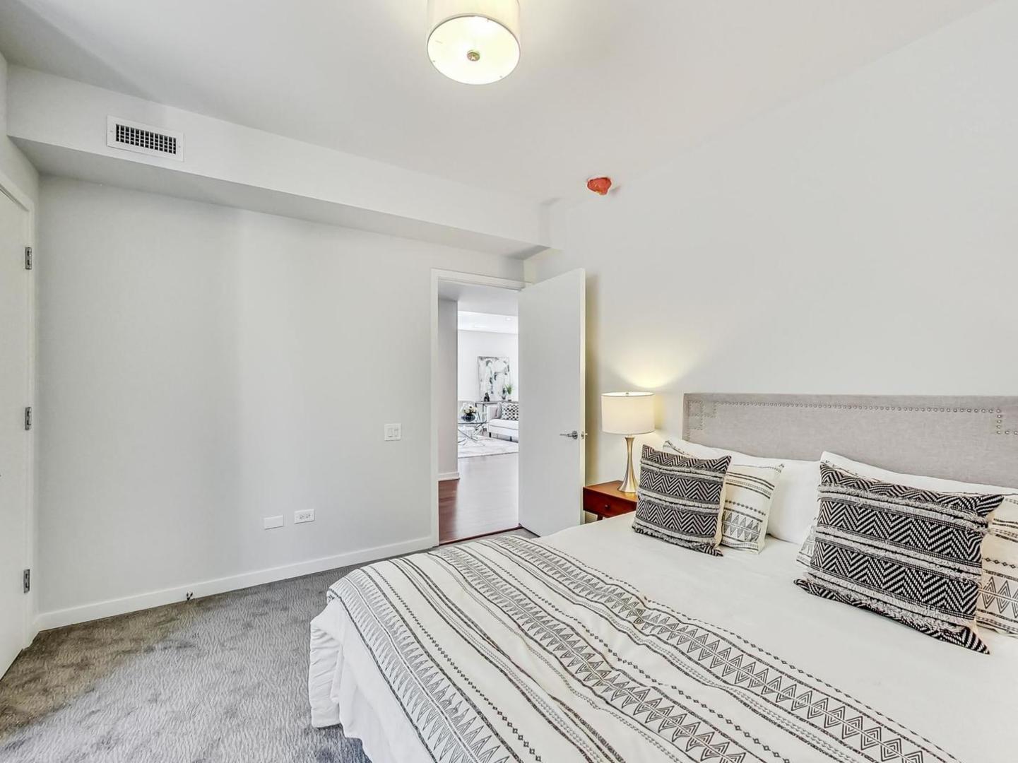 5691 North Ridge Avenue, Unit 201 Chicago, IL 60660 - Photo 23 of 31 a bedroom with a bed and a chandelier