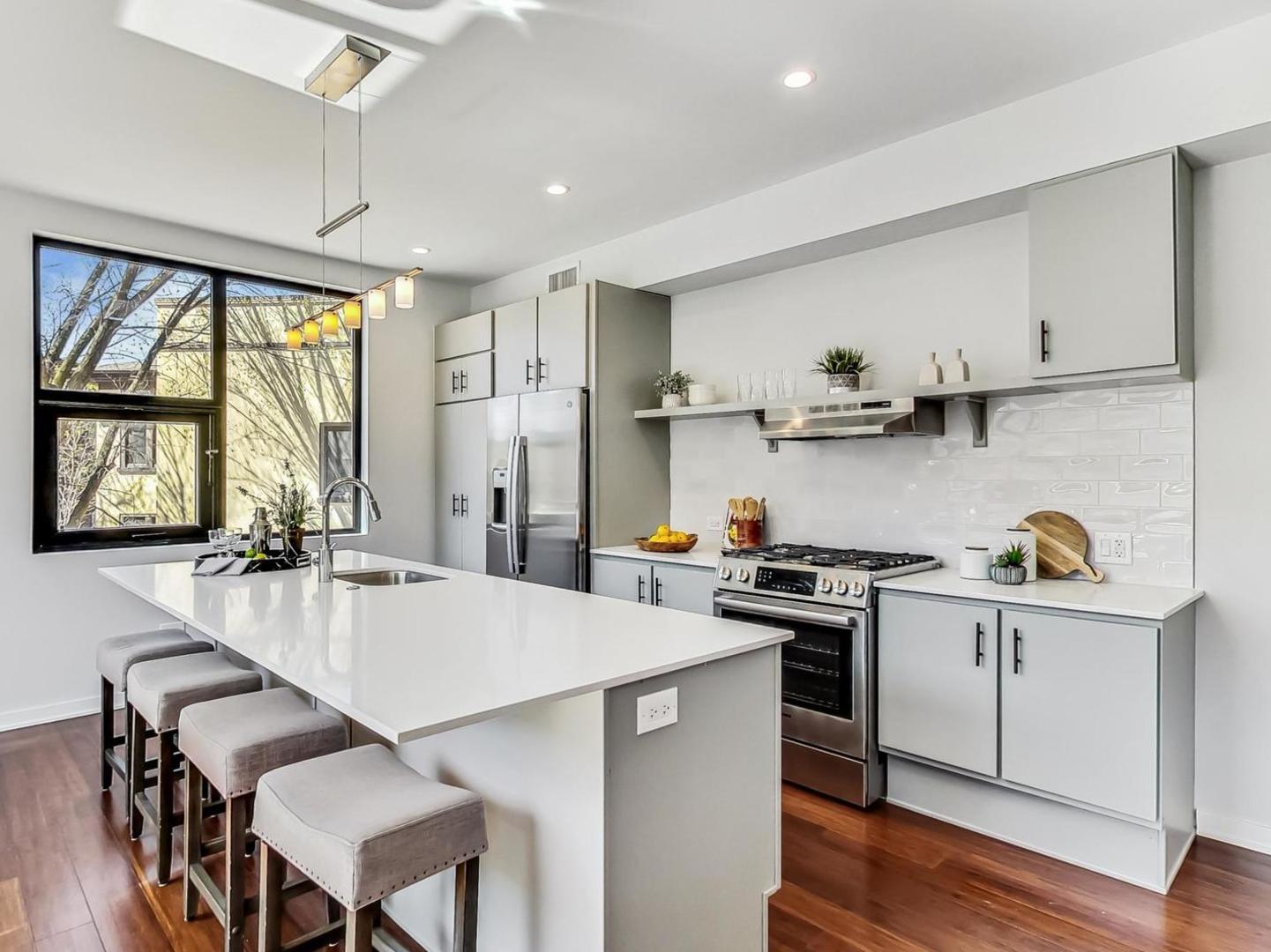 5691 North Ridge Avenue, Unit 201 Chicago, IL 60660 - Photo 5 of 31 a kitchen with kitchen island a stove a table and chairs in it