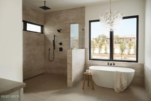 a spacious bathroom with a bathtub and chandelier