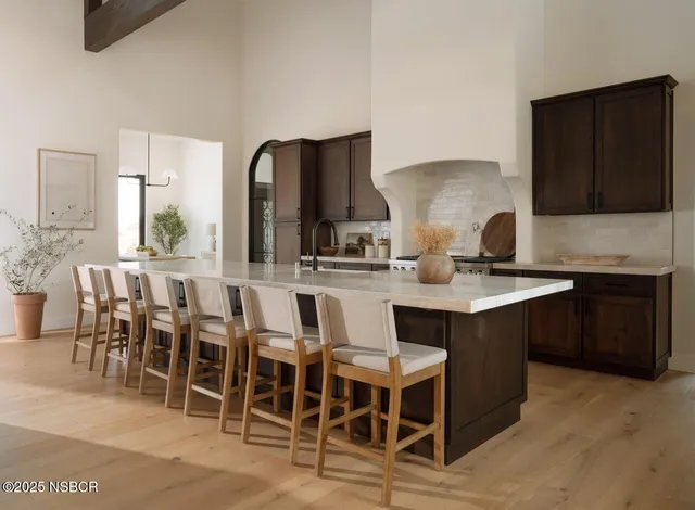 a kitchen with stainless steel appliances granite countertop a table chairs sink and cabinets