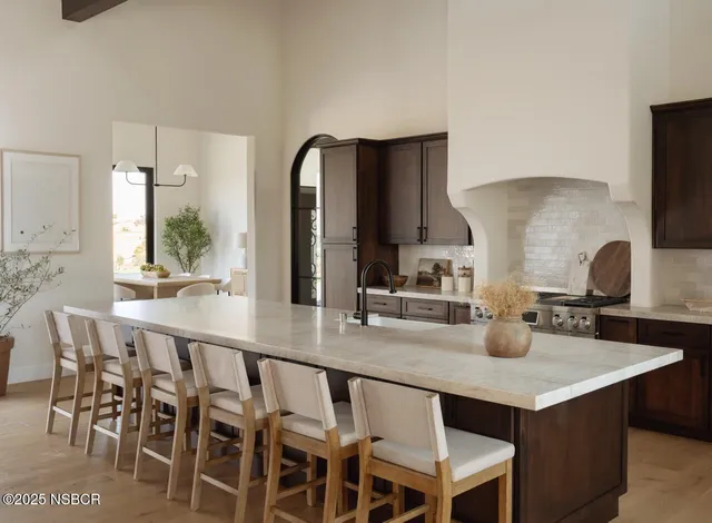 a kitchen with cabinets a sink and chairs in it