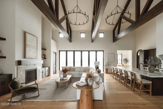 a living room with furniture a fireplace and a dining table with wooden floor