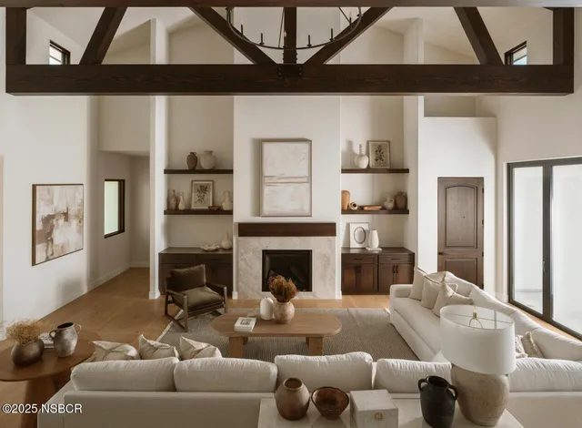 a living room with furniture kitchen view and a large window