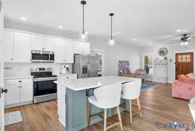 a kitchen with stainless steel appliances kitchen island granite countertop a stove a sink a dining table and chairs