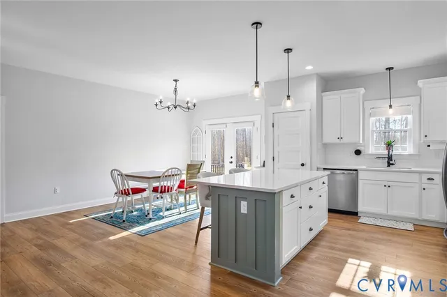 a kitchen with a sink stove and wooden floor