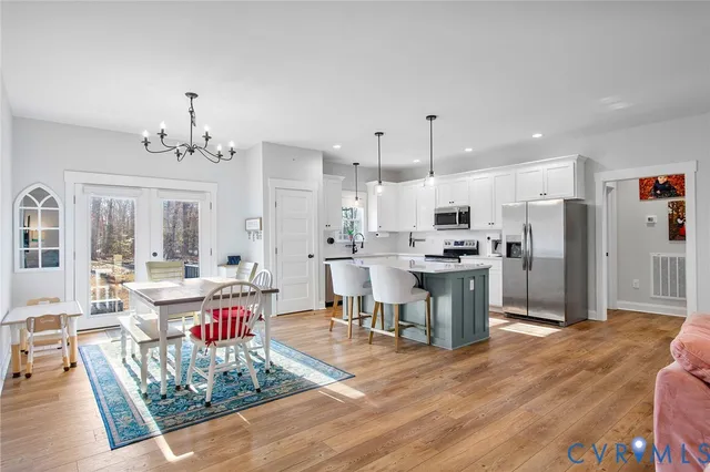 a living room with stainless steel appliances kitchen island granite countertop furniture wooden floor and a view of kitchen