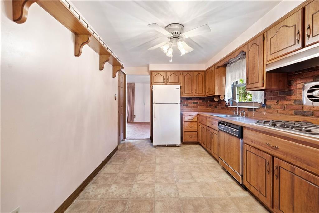 106 Fenway Road Pittsburgh, PA 15209 - Photo 11 of 25 a kitchen with stainless steel appliances granite countertop a refrigerator a sink dishwasher a stove with wooden cabinets